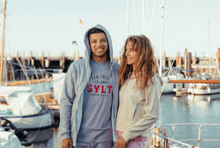 Junge Frau und Mann in North Frisian Island Sylt Hoodies am Yachthafen, Modekleidung für Paare, entspanntes Hafenambiente